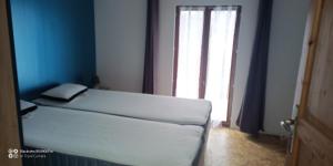 Saint-Julien-le-Vendômoisにあるpetite maisonetteの白いベッドと大きな窓のある寝室