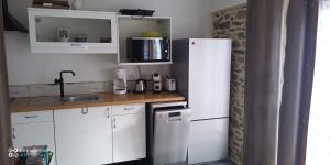 Saint-Julien-le-Vendômoisにあるpetite maisonetteの白いキャビネットと白い冷蔵庫のあるキッチン