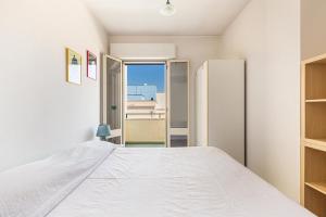 una camera con letto bianco e frigorifero di Salentoandmore - Terrazzo sul Mare a Torre Pali