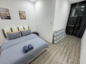a bedroom with a bed with blue slippers on it at Podium Home2 for 7pax at AEON Mall Kuching in Kuching