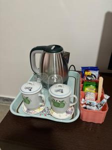 a tray with two coffee cups and a tea kettle at Arcane viewfinder homestay in Gangtok