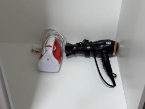 a red and white blow dryer sitting on a wall at Podium Home2 for 7pax at AEON Mall Kuching in Kuching