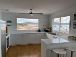 a kitchen with white cabinets and a white counter top at Mariners Retreat in Whyalla