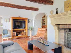 a living room with a table and a fireplace at Le Mas Valou, villa en pierre dans les hauteurs de Fayence in Tourrettes