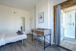 トゥールーズにあるLe petit Strasbourg hypercentreの机とベッドと窓のある寝室