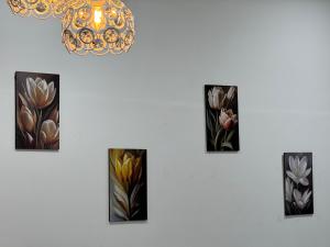 a wall with four paintings of flowers on it at Podium Home2 for 7pax at AEON Mall Kuching in Kuching