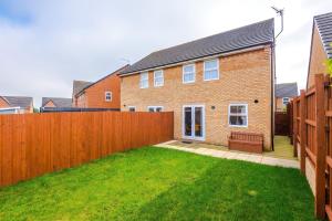 a fence in front of a house with a yard at Vibrant Home in Crewe by 53 Degrees Property, Ideal for Business, FREE Parking! in Crewe