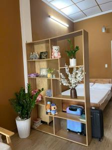 a room with a bed and shelves with plants at Pamela Homestay in Thôn An Hòa