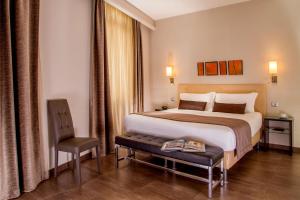 a hotel room with a large bed and a chair at Basilio 55 Rome in Rome