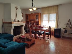 un soggiorno con camino, tavolo e sedie di Casa Rogelio Valverde a Valverde de la Vera