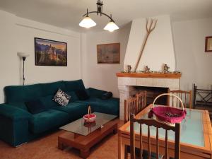 un soggiorno con divano verde e camino di Casa Rogelio Valverde a Valverde de la Vera Altre 39 foto