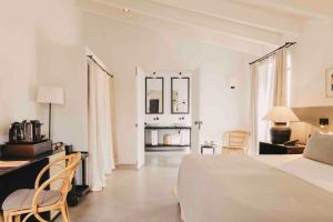 a white bedroom with a bed and a table and chairs at Finca Serena Mallorca, Small Luxury Hotels in Montuiri