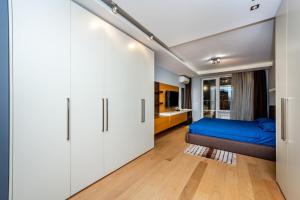 a bedroom with white cabinets and a blue bed at Sofia Luxury 3-Bed Penthouse Apartment Sleeps 6 in Sofia