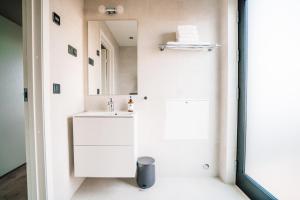 Un baño blanco con lavabo y espejo. en Blue View Cabins, en Reykholt 49 fotos más