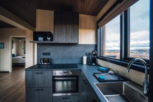 cocina con fregadero y ventana grande en Blue View Cabins, en Reykholt