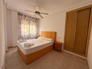 a bedroom with a bed and a ceiling fan at Las Gondolas by Alina365 in La Manga del Mar Menor +83 photos
