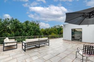 a patio with two benches and an umbrella at Braham Lodge - The Octave 3 in Johannesburg