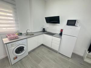 a kitchen with a washing machine and a sink at Holliday 2 La Cala in Cala del Moral