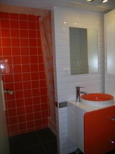 a red bathroom with a sink and a mirror at Gîte du Marronnier in Magné +8 photos