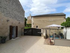 a patio with an umbrella next to a building at Gîte du Marronnier in Magné