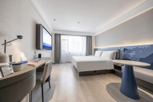 a hotel room with a bed and a desk at Atour Light Hotel Hefei Huaihe Road Pedestrian Street Provincial Hospital in Hefei