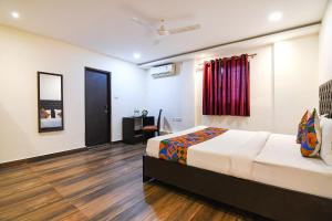 a hotel room with a bed and a window at FabHotel KGF in Kolkata