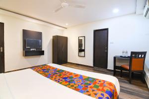 a bedroom with a bed and a desk and a tv at FabHotel KGF in Kolkata