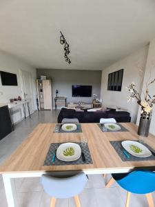 a dining room and living room with a table and chairs at O'fil du Doubs Apartment in Labergement-Sainte-Marie