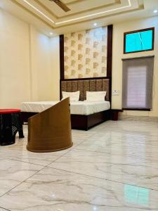 a room with two beds and a couch in it at Lotus Hotel in Kurukshetra