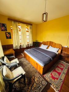 a bedroom with a bed and a chair at Hemisphere Boutique Farm Stay in Nagar