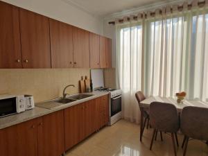 a kitchen with wooden cabinets and a table with a microwave at Lumari Living in Ballsh