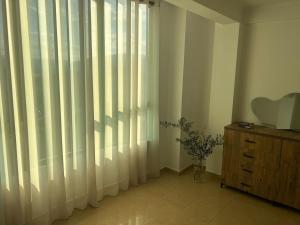 a room with a window with sheer curtains and a dresser at Lumari Living in Ballsh