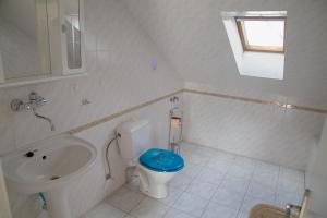 a white bathroom with a toilet and a sink at Český ráj - apartmán in Žehrov