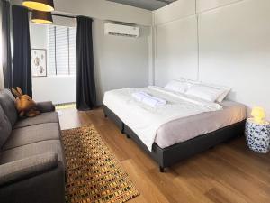 a bedroom with a bed and a couch at Human Touch Room - Soulful Bangkok Hideout in Lat Krabang