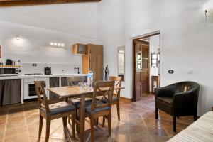 een keuken en eetkamer met een tafel en stoelen bij Hacienda Riogordo in Ríogordo