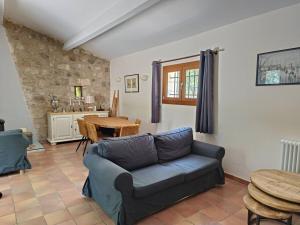 un soggiorno con un divano e un tavolo di Villa Provence élégante climatisée a Oppède