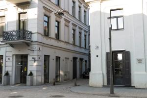 a white building on a city street with a street sign at Kaunas Old Town Apartment in Kaunas