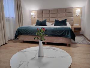 1 dormitorio con 1 cama con un jarrón sobre una mesa en Hotel Chata Za Wsią, en Mysłakowice