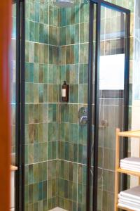 a bathroom with a shower with green tiles at Kaunas Old Town Apartment in Kaunas +37 photos