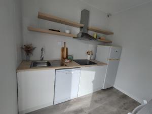 a white kitchen with a sink and a refrigerator at Oktheway Corme in Corme-Puerto +12 photos