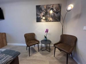 una stanza con due sedie e un tavolo con una lampada di Apartement 1 a Breitenbach