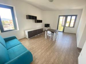 a living room with a blue couch and a table at Casa Passeri in San Teodoro