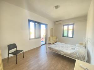 a bedroom with a bed and a chair in it at Casa Passeri in San Teodoro