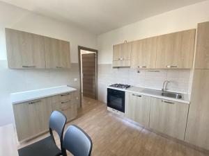 a kitchen with wooden cabinets and a sink and a stove at Casa Passeri in San Teodoro