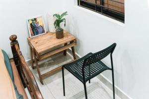 een tafel en een stoel in een kamer bij The Last Stop Backpackers Hostel in Auroville