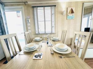 a dining room table with plates and glasses on it at Beach Retreat in Filey
