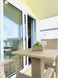 a table and chairs on a porch with a glass of wine at Beach Retreat in Filey +53 photos