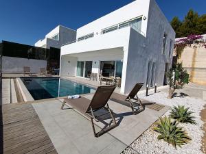 a house with a swimming pool and two chairs at Charming Villa with a Pool in Alanya