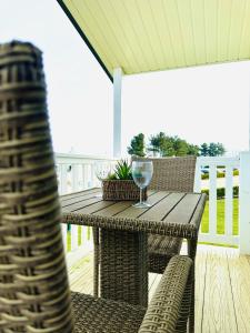 a wooden table with wine glasses on a deck at Beach Retreat in Filey