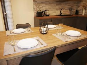 una mesa de madera con placas blancas en la parte superior. en Modern Two-Bedroom Flat, 10 Mins Walk To The Beach, en Quartu SantʼElena